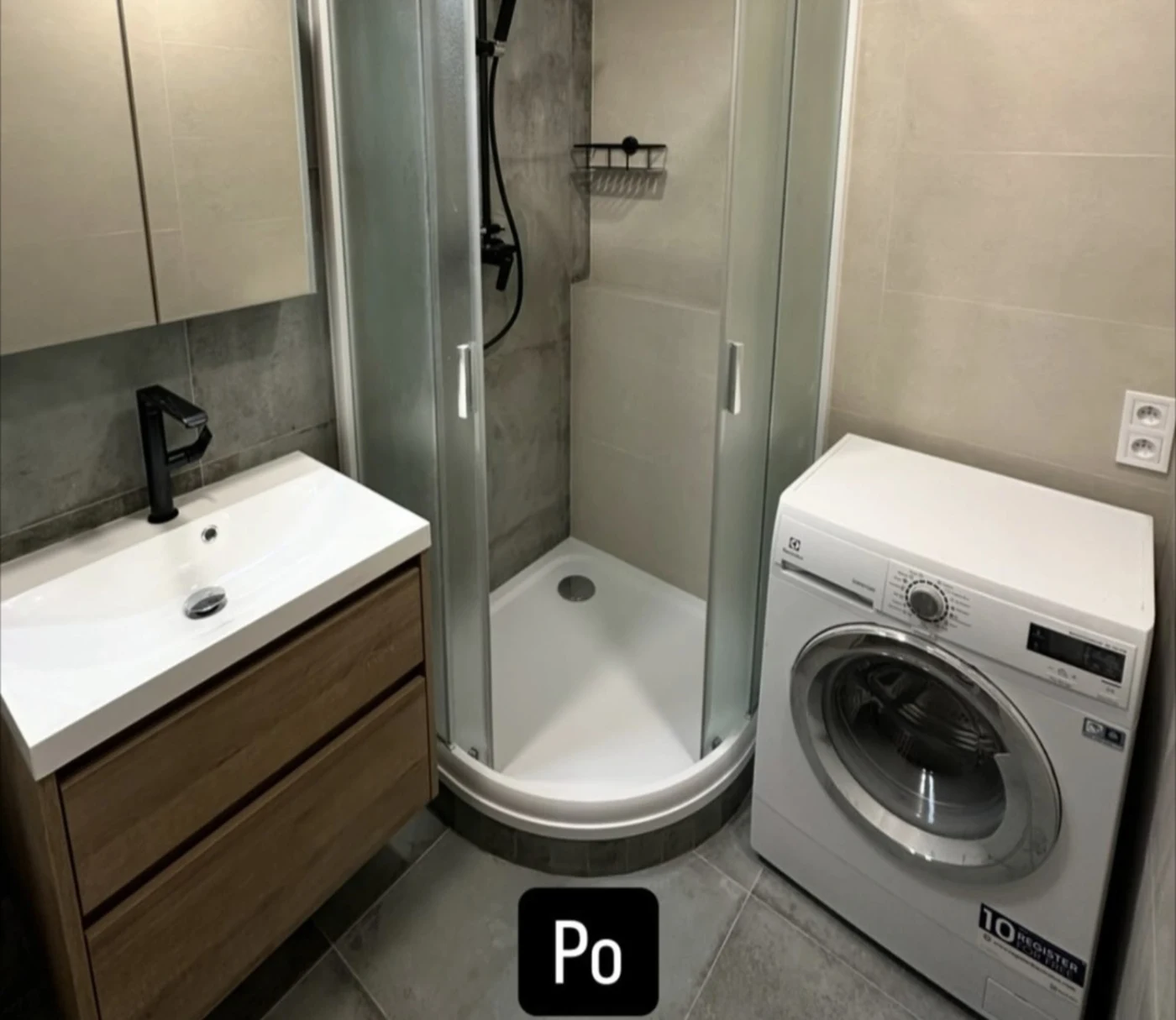 Moderní koupelna se sprchovým koutem, dřevěnou skříňkou a pračkou